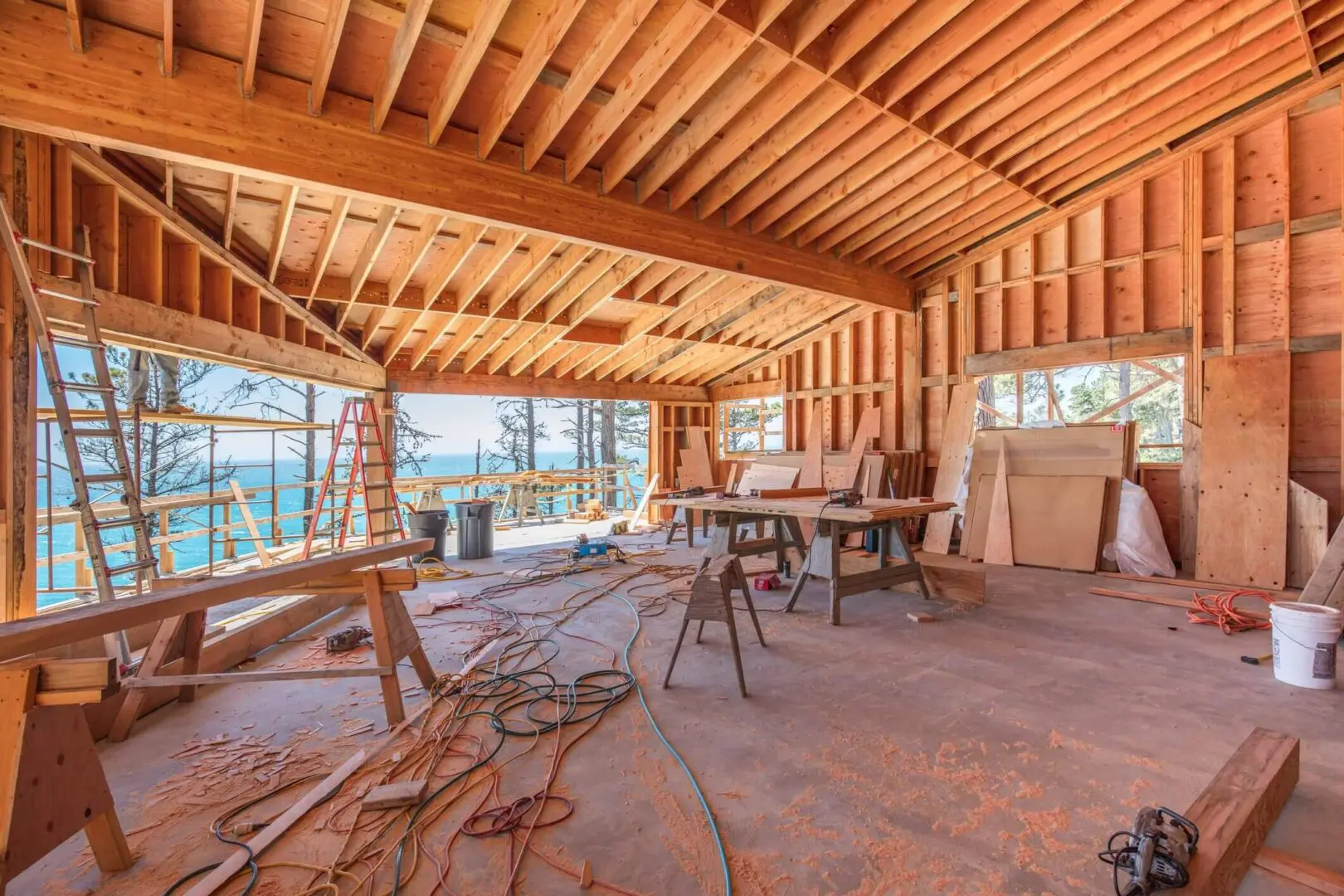 Interior of a wooden structure under construction with tools and materials scattered around.
