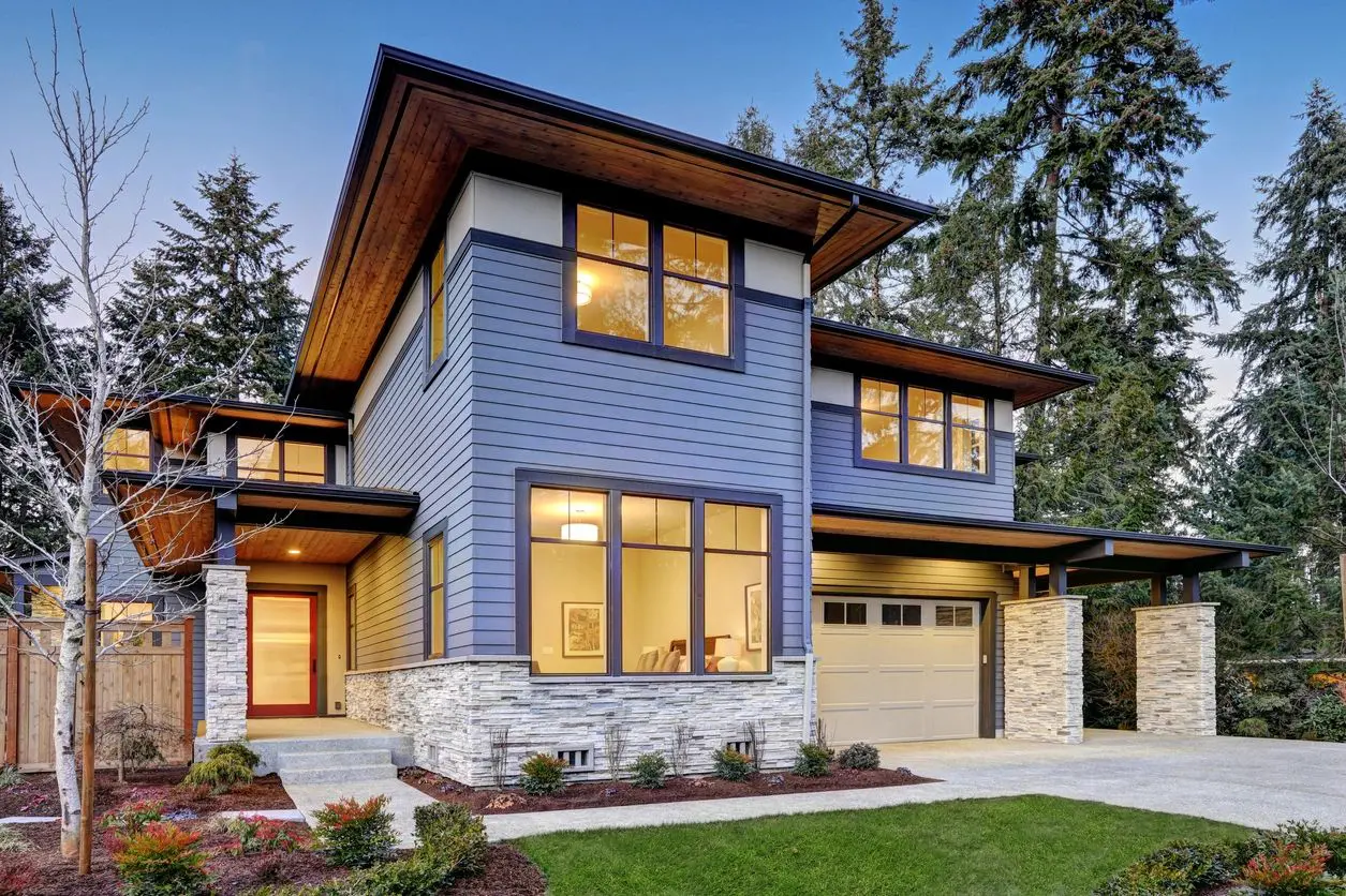 Modern two-story house with large windows and a wooden roof.