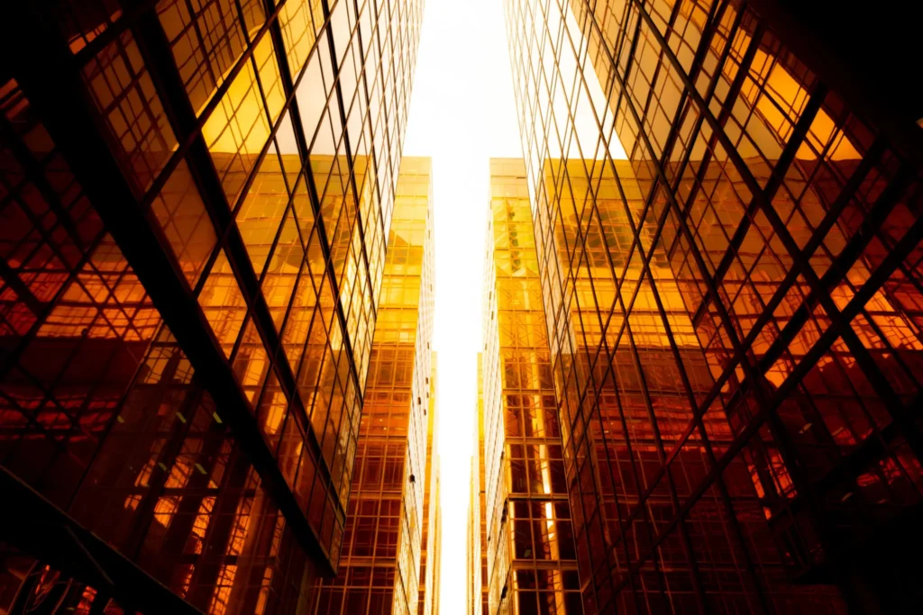 Golden skyscrapers reflecting sunlight, upward view.